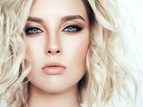 Frau mit Nude Make-up, strahlender Haut und soften Beach Waves