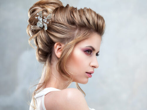 Braut mit eleganter Hochsteckfrisur und Haarschmuck im seitlichen Profil