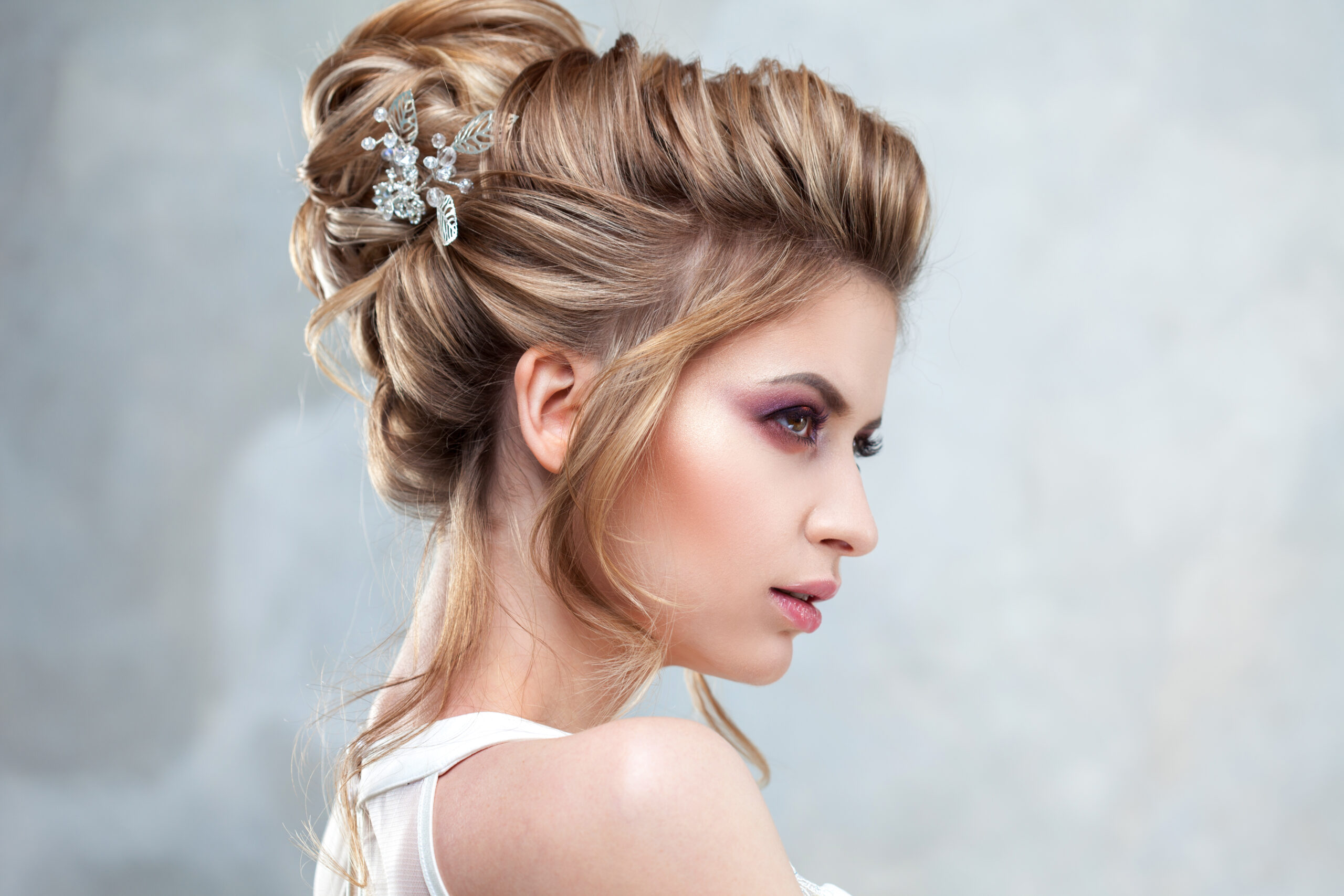 Braut mit eleganter Hochsteckfrisur und Haarschmuck im seitlichen Profil