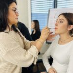 Teilnehmerin der Make-up Expert Ausbildung bei MIA. Dein Make-up Coach schminkt ein Modell im Rahmen eines praxisnahen Make-up Coachings
