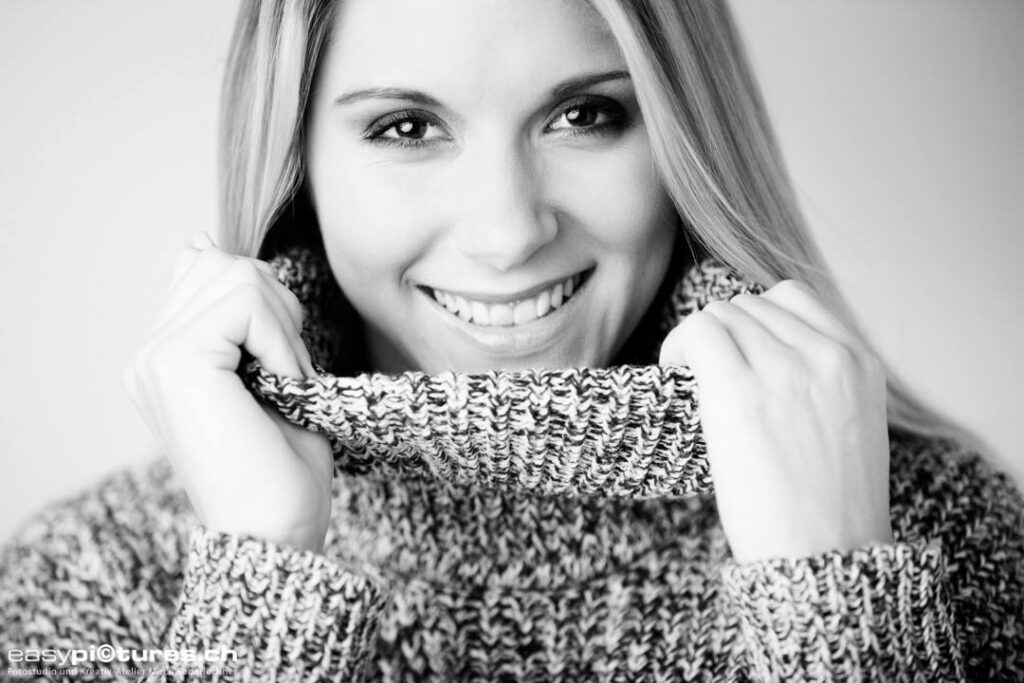 Schwarz-weiss Portrait einer Frau im Strickpullover mit natürlichem Make-up