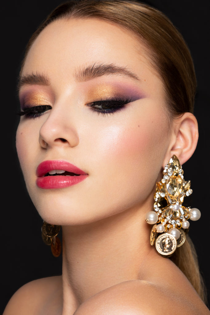 Elegantes Beauty Make-up mit goldenen Lidschatten, Glow Skin und auffälligen Statement-Ohrringen