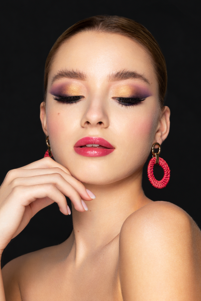 Beauty Make-up mit gold-lila Lidschatten, Glow Teint und glänzenden Lippen