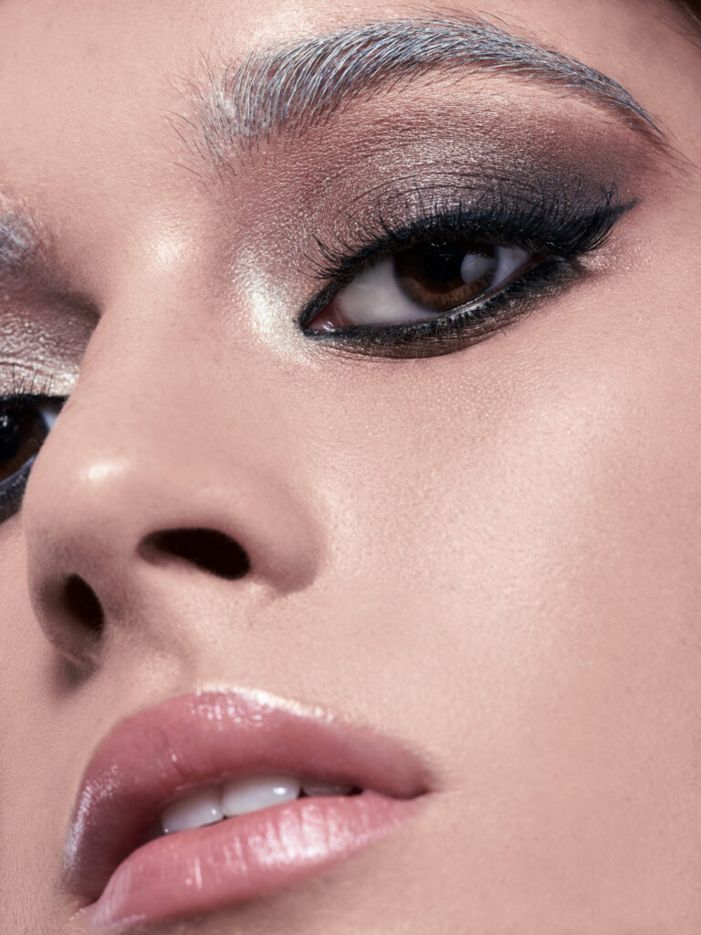 Nahaufnahme eines Auges mit schimmerndem Nude Augen-Make-up, definierten Wimpern und natürlichem Glow